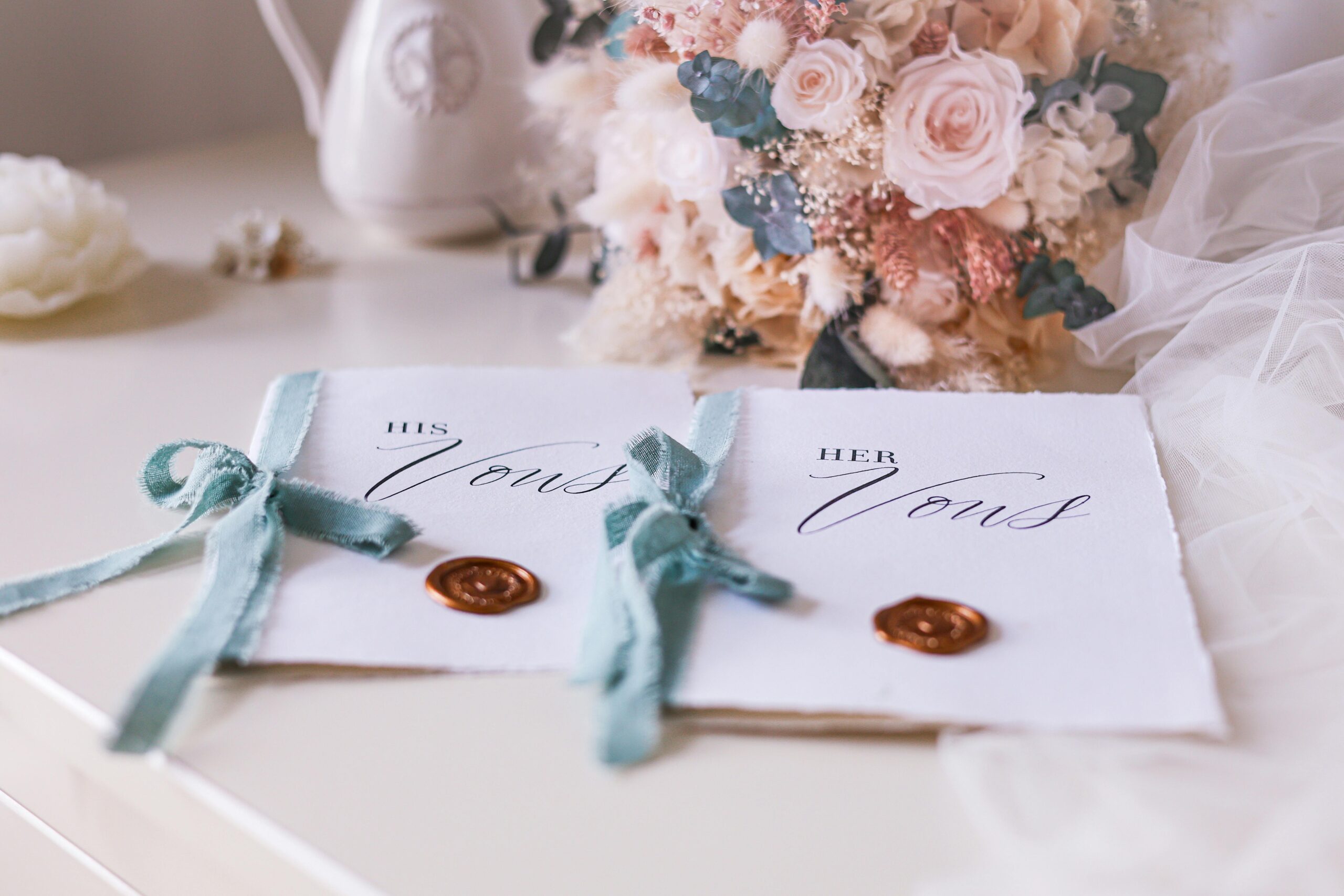 Beautiful wedding vow cards with blue ribbons and a floral bouquet, perfect for a romantic setting.